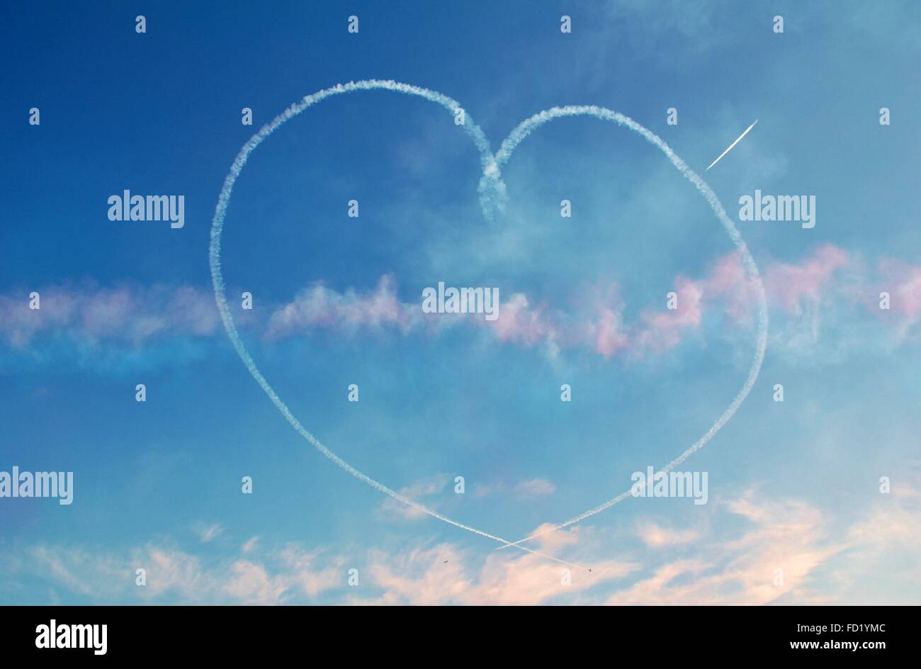 Düsenflugzeuge erstellen eine herzförmigen Rauchfahne in den Himmel. Stockfoto