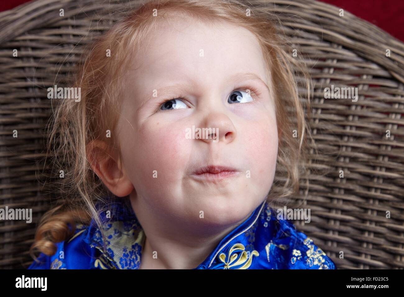 Kleines Mädchen hart in Studioportrait denken. Lustig und natürlichen Ausdruck. Stockfoto