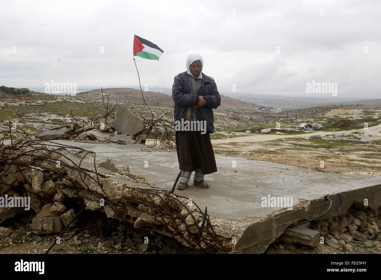 Hebron, Westjordanland, Palästinensische Gebiete. 27. Januar 2016. Ein palästinensischer Mann betet auf den Ruinen einer Moschee während eines Schneesturms im Westjordanland Dorf von Mufagara, südlich von Hebron 27. Januar 2016 Credit: Wisam Hashlamoun/APA Bilder/ZUMA Draht/Alamy Live News Stockfoto