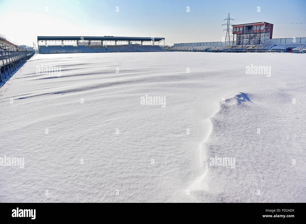 Leeren Tribünen und ein Fußballstadion mit Schnee bedeckt nach starkem Schneefall Stockfoto