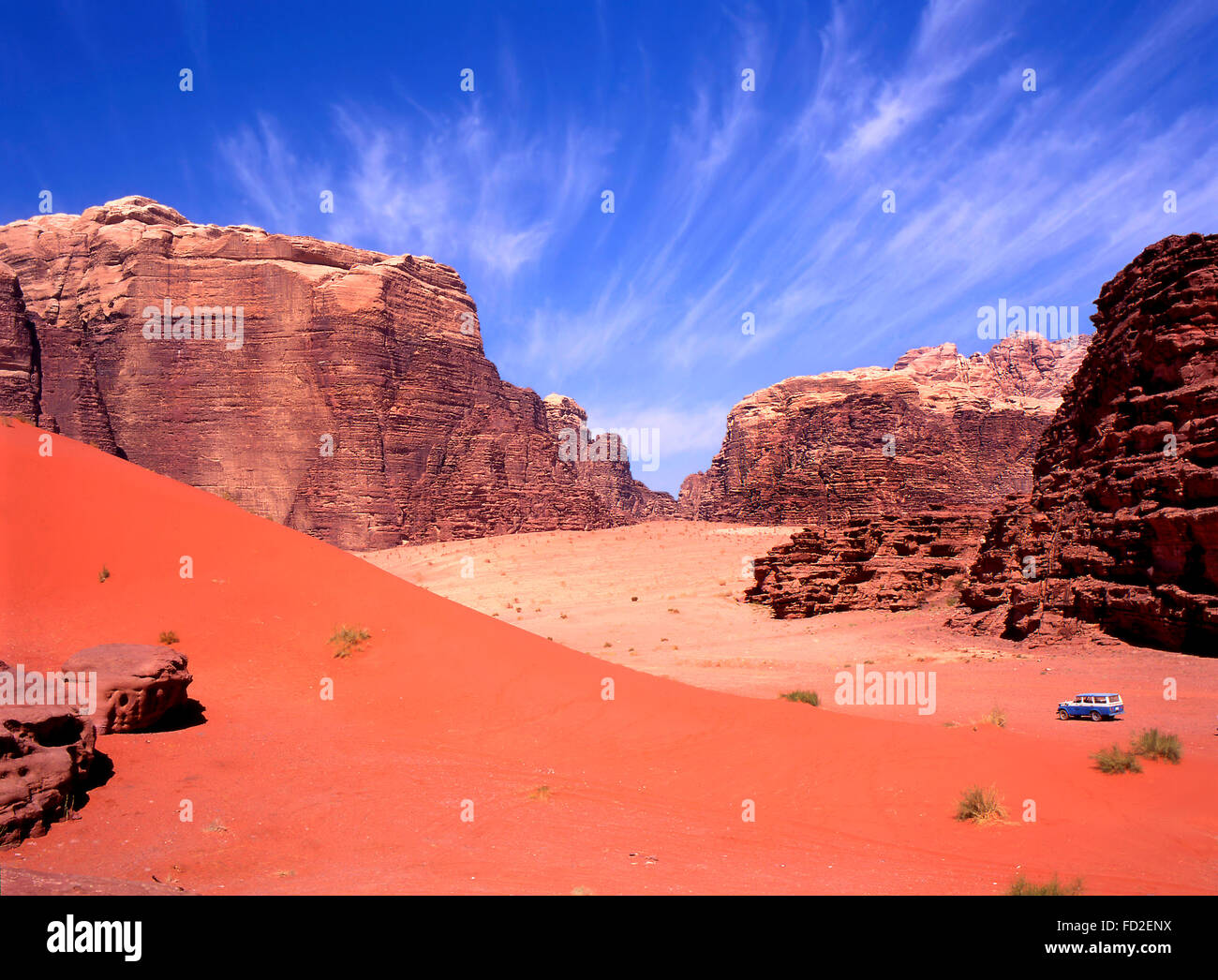 Allradantrieb in Wadi Rum, Jordanien. Blauer Himmel verblasst, roter Sand mit Touristen in 4wd auf einer Tour in dieser Wüste. Stockfoto