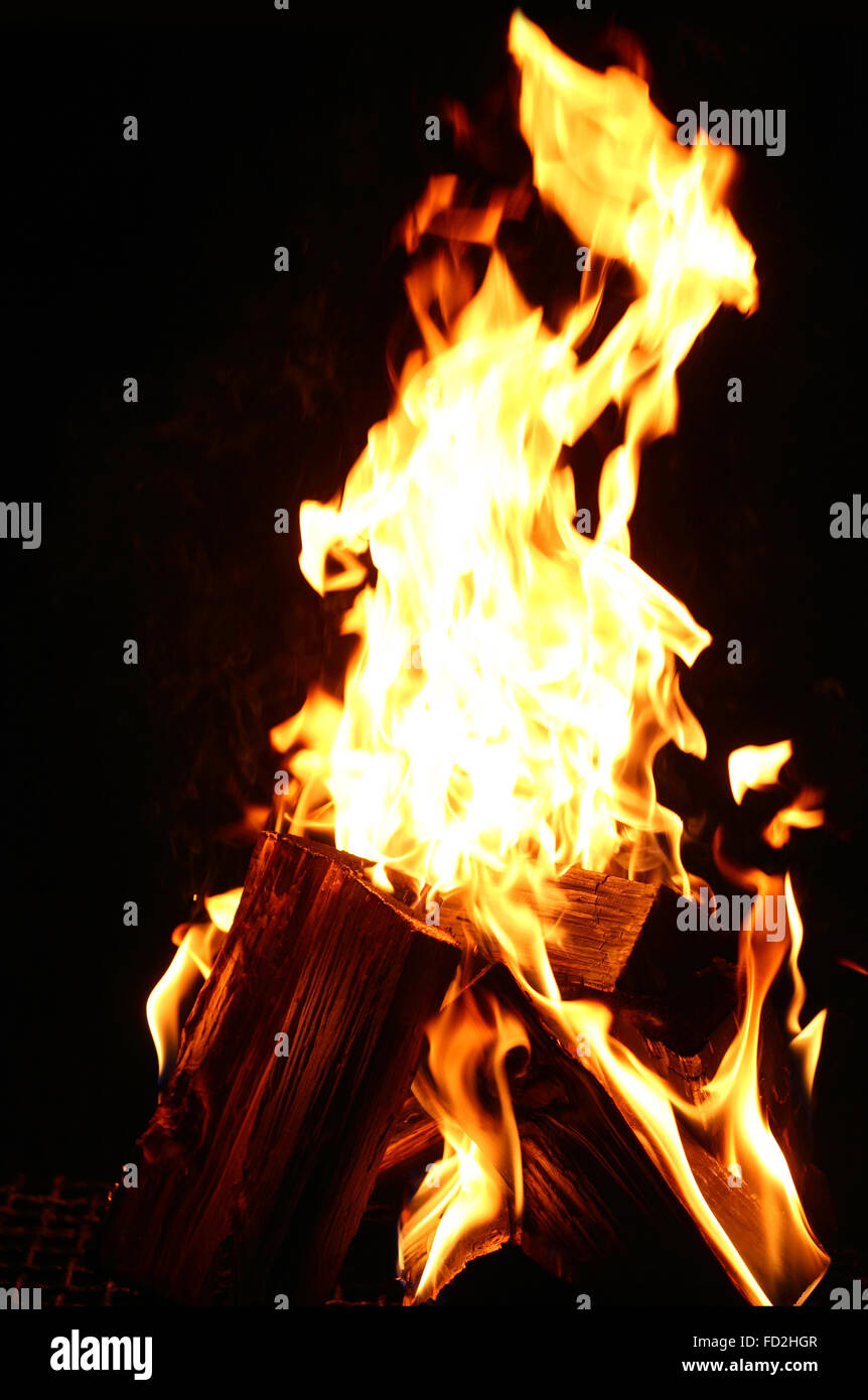 Flamme auf das Brennholz auf dem dunklen Hintergrund closeup Stockfoto
