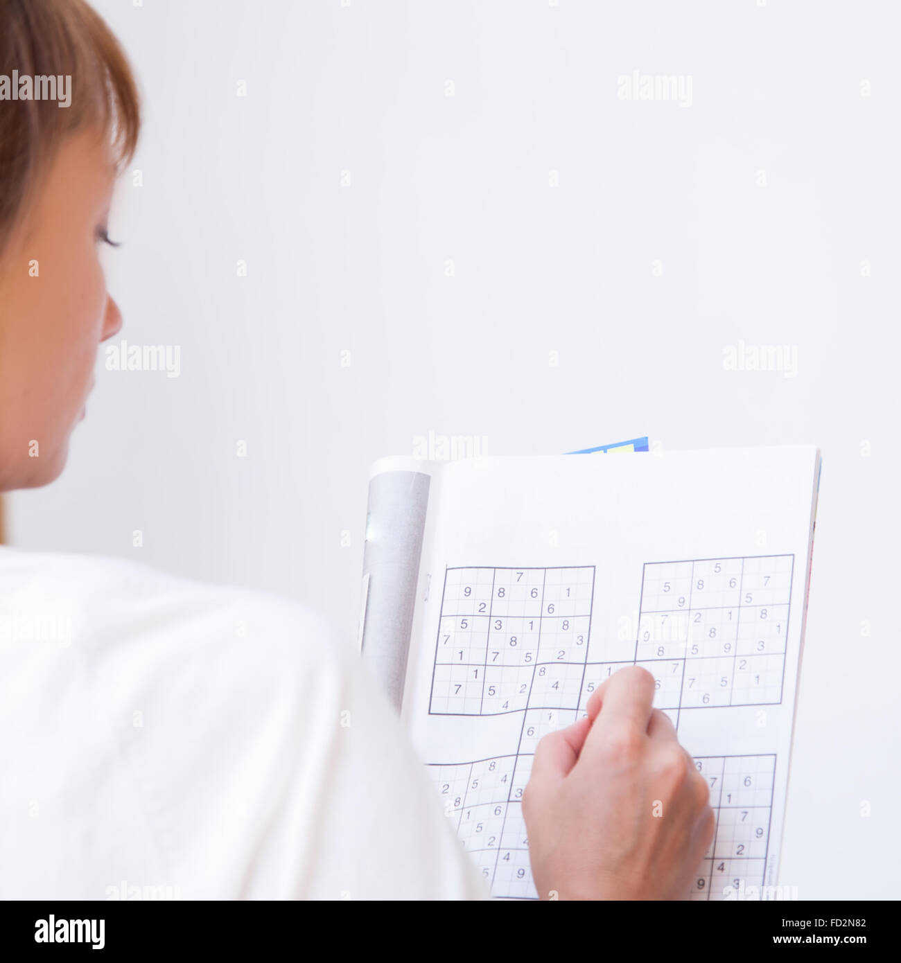 Frau macht Kreuzworträtsel Stockfoto