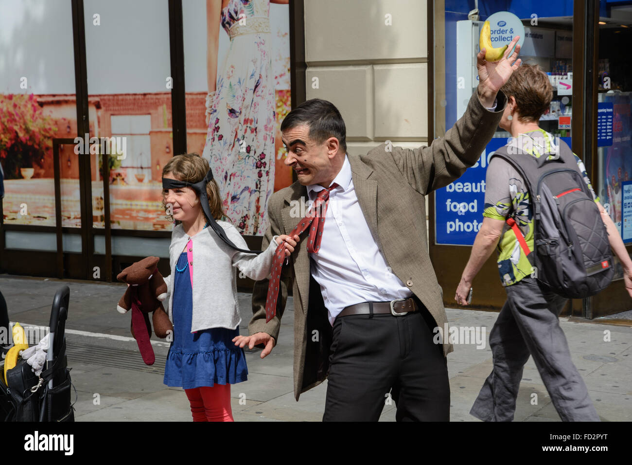 Straßenkünstler, Mr. Bean zu imitieren und posiert mit einem Mädchen Stockfoto