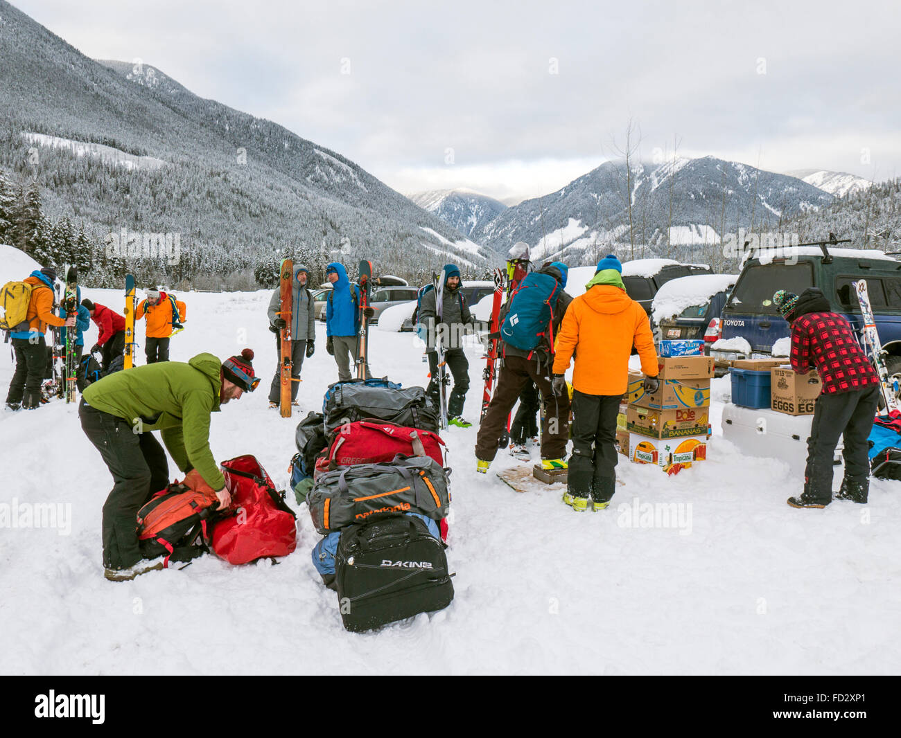 Backcountry Skifahrer wiegen und bereiten Sie Rückstellungen für Hubschraubertransporte zu entfernten Mount Carlyle Lodge; Britisch-Kolumbien Stockfoto