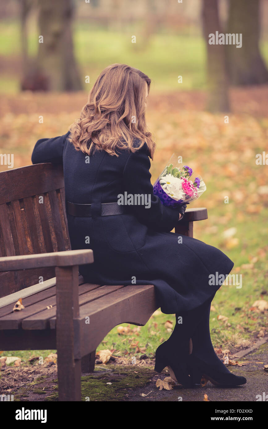 Trauernde Frau saß auf der Bank bei einer Beerdigung Dienst (inszenierten) Stockfoto