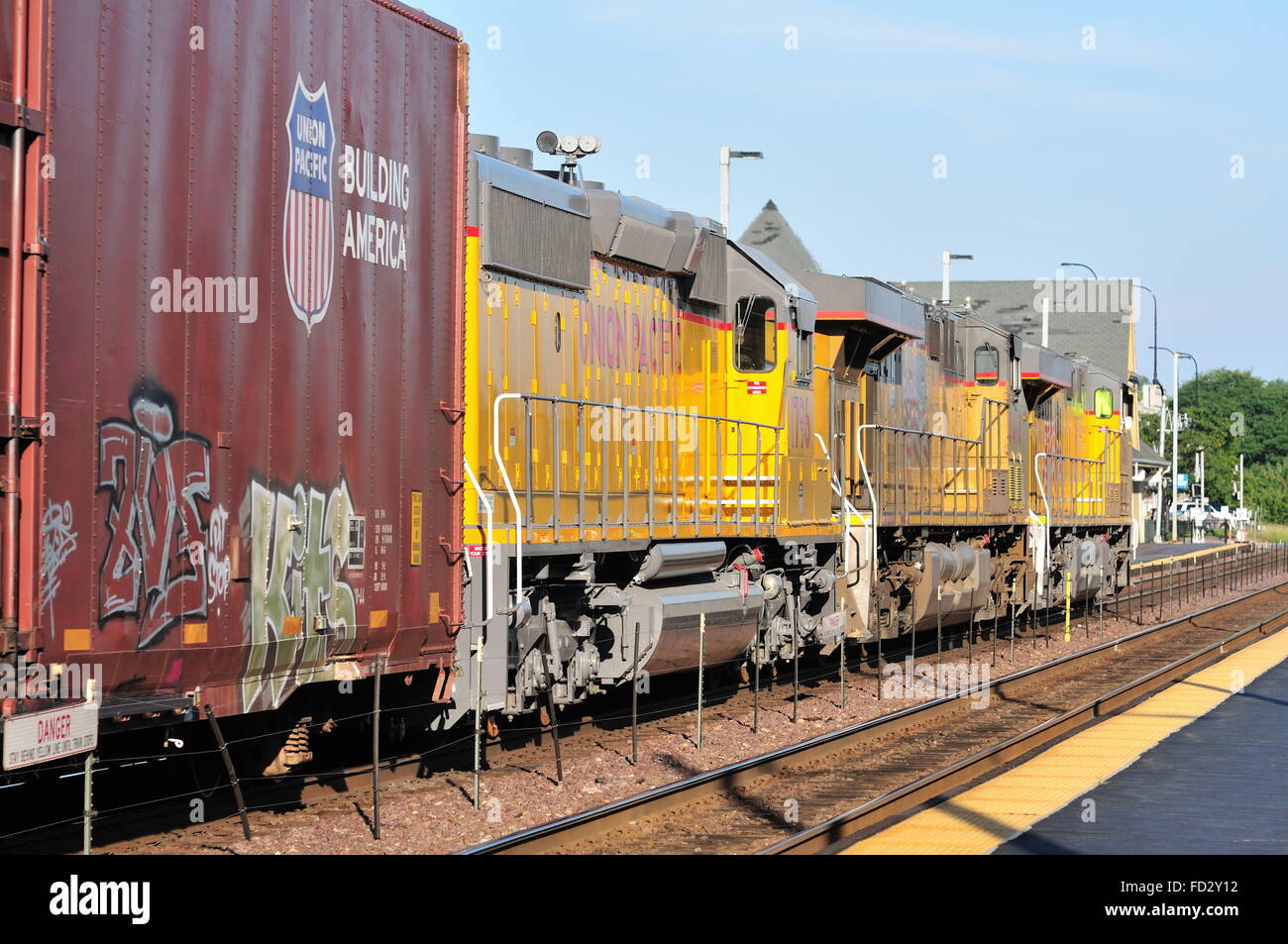 Eine ostwärts Güterzug für Chicago rumpelt durch Geneva, Illinois an einem späten Abend September bestimmt. Stockfoto