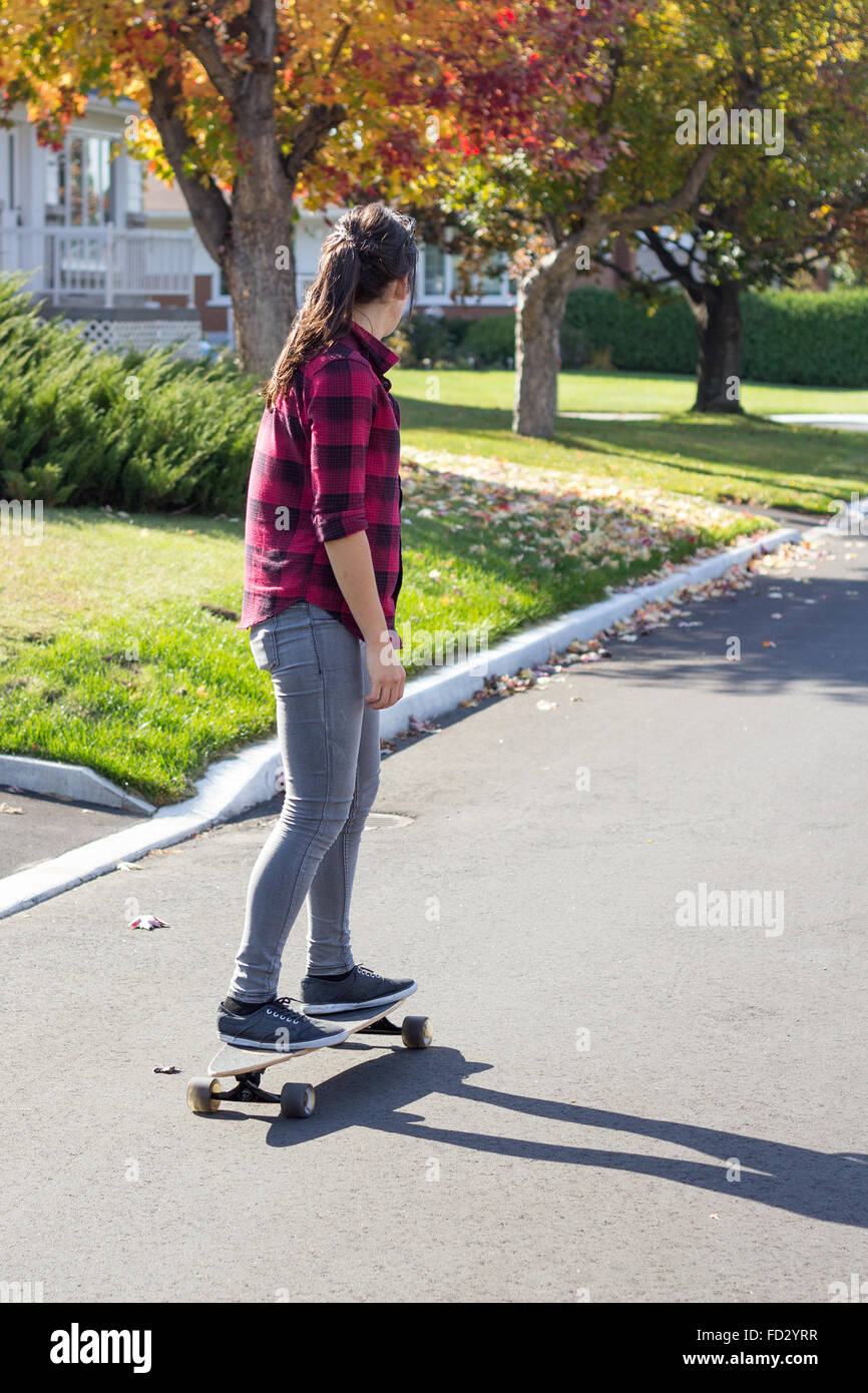 Frauen reiten Longboard Skateboard im freien tagsüber im Herbst in Quebec Provinz Kanada Stockfoto