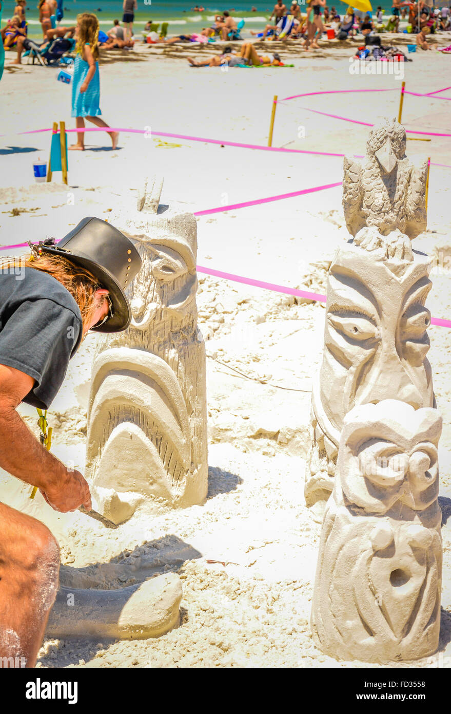 Ein Mann arbeitet auf einer aufwendigen Sandburg Konstruktion erinnert an Totempfähle während eines Wettkampfes am Siesta Key Beach, FL Stockfoto