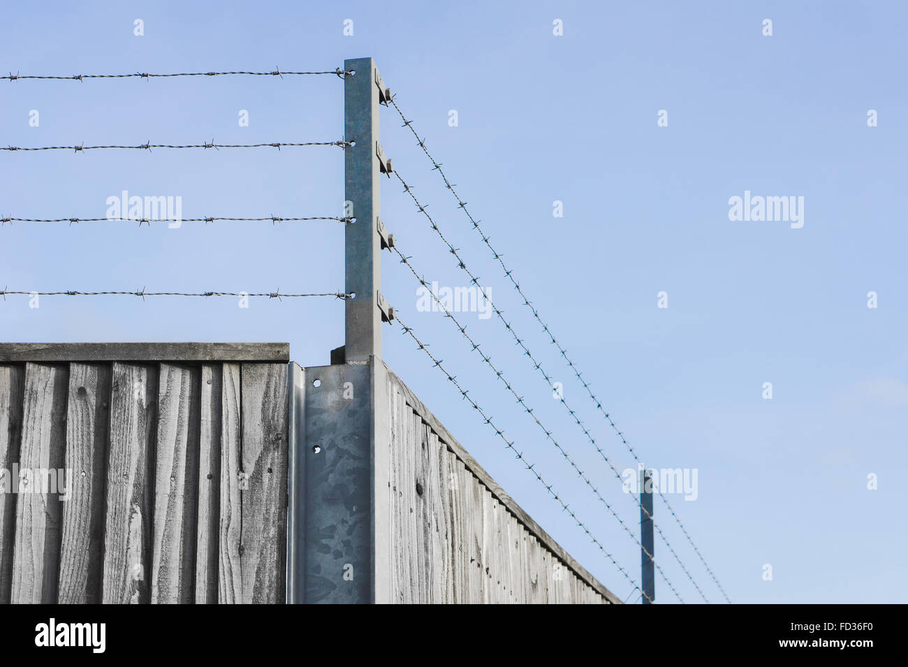 Stacheldraht auf der Oberseite einen hölzernen Zaun Stockfoto