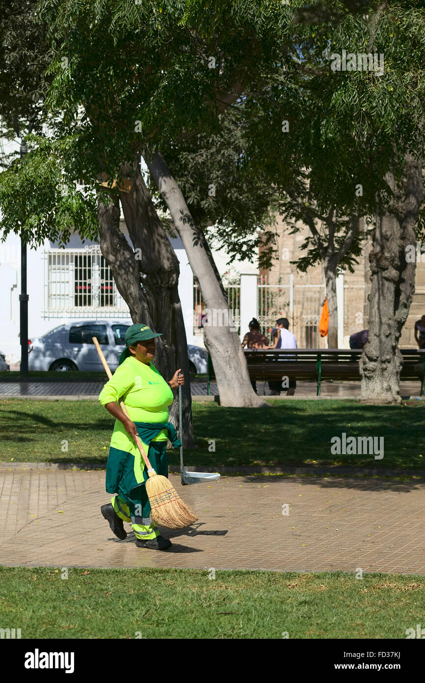 LA SERENA, CHILE - 19. Februar 2015: Frau in grüner Uniform tragen einen Besen und einer Schaufel auf dem Hauptplatz Plaza de Armas Stockfoto