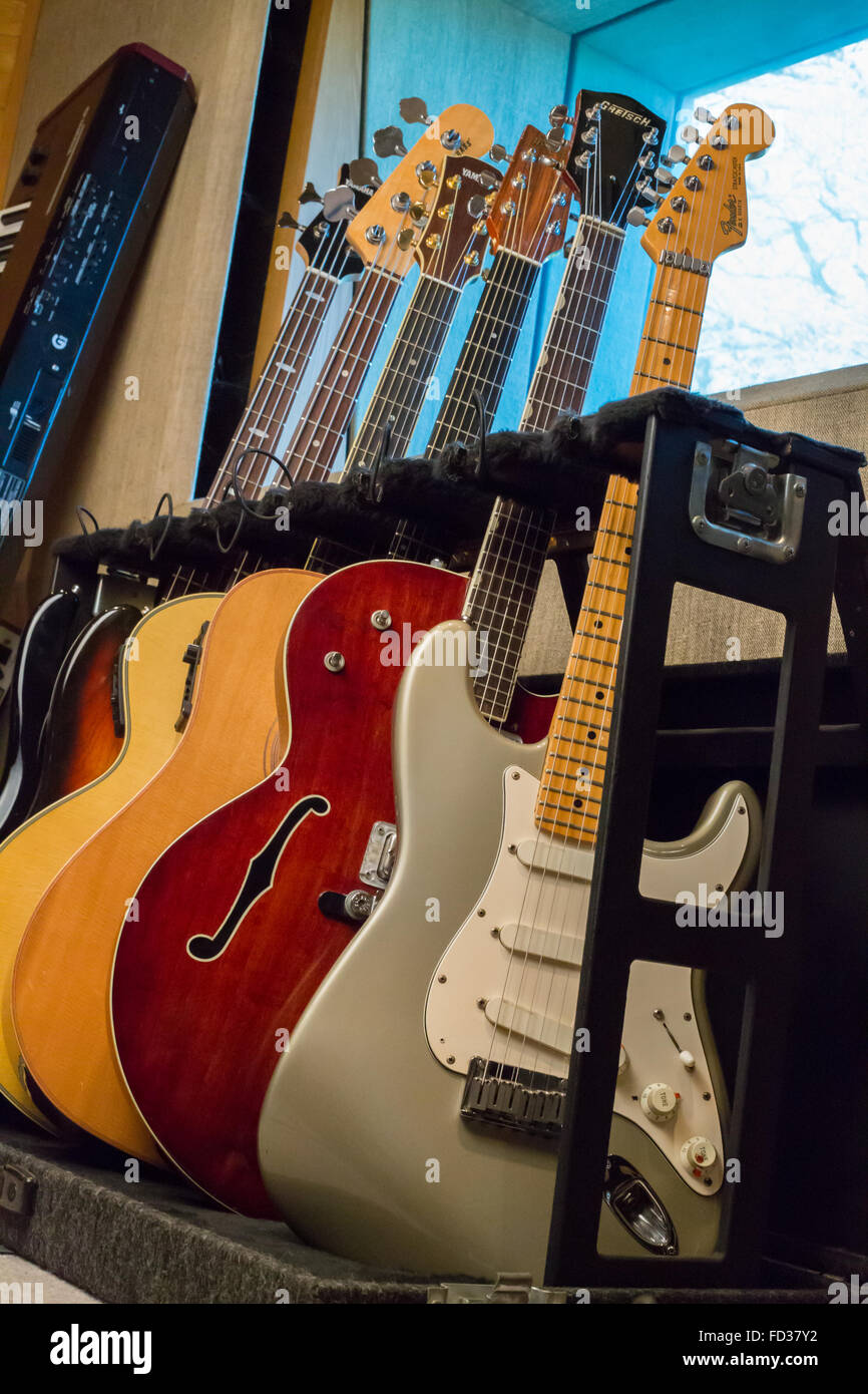 Eine Auswahl an e-Gitarren, akustische Gitarren und elektrischen Bassgitarren auf einem Gestell in einer Aufnahme Studio Yamaha Kotflügel Stockfoto