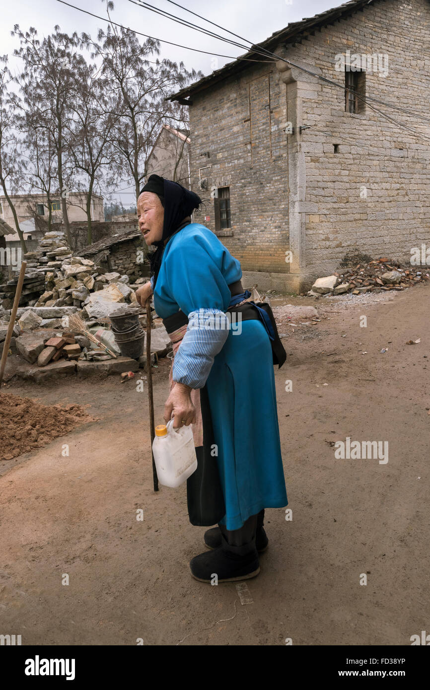 Straßenszene mit alten Han (Tunpu) Frau und typisches Steinhaus, Liuguan alte Han Dorf, Guizhou Provinz, China Stockfoto