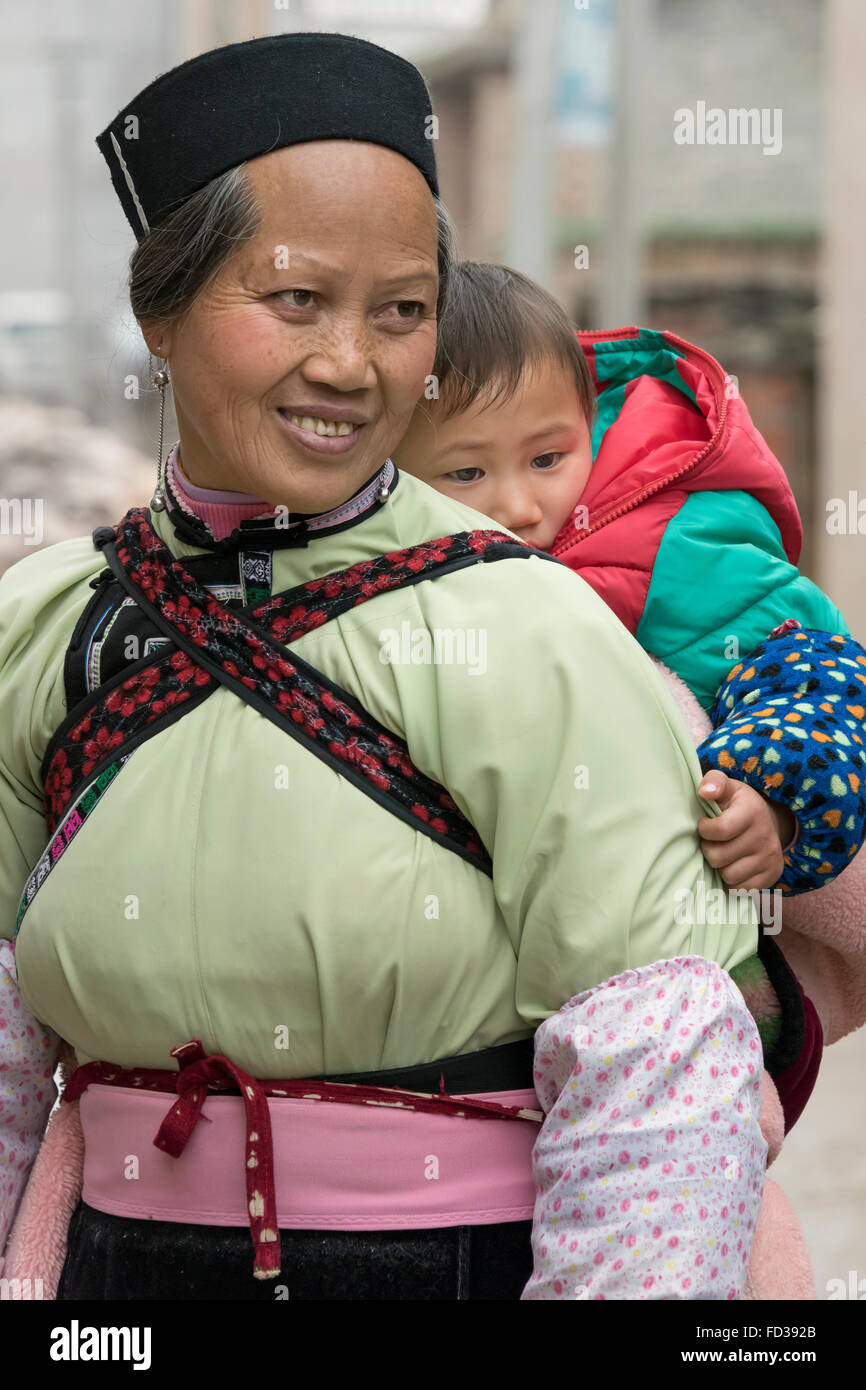 Alten Han-Frau mit einem Baby auf ihrem Rücken, Liuguan alte Han Dorf, Guizhou Provinz, China Stockfoto