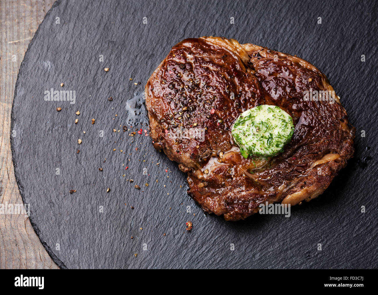 Black Angus Steak Entrecote mit Kräuterbutter auf Stein Schiefer Platte Stockfoto