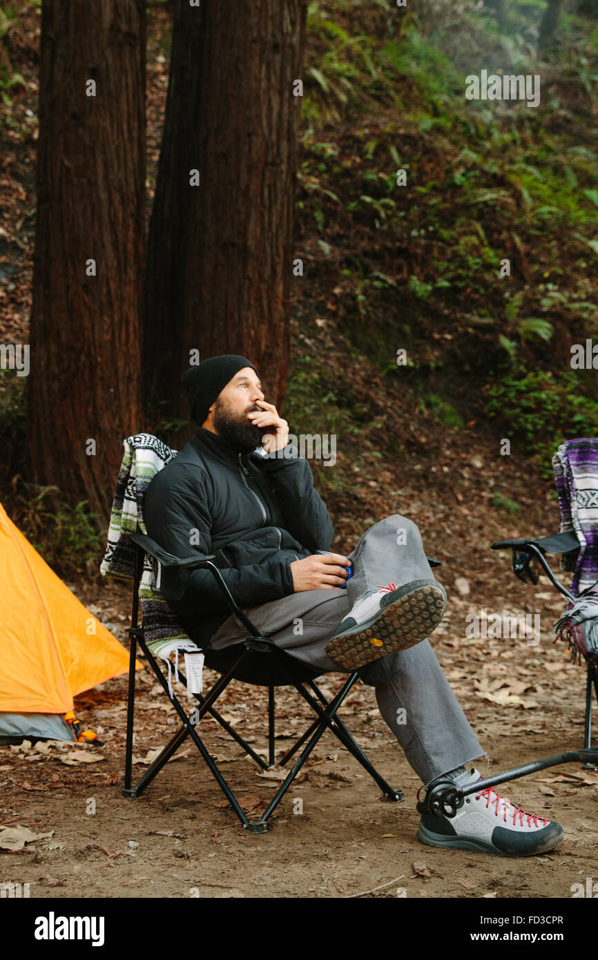 Ein junger Mann sitzt auf dem Campingplatz in Big Sur, Kalifornien. Stockfoto