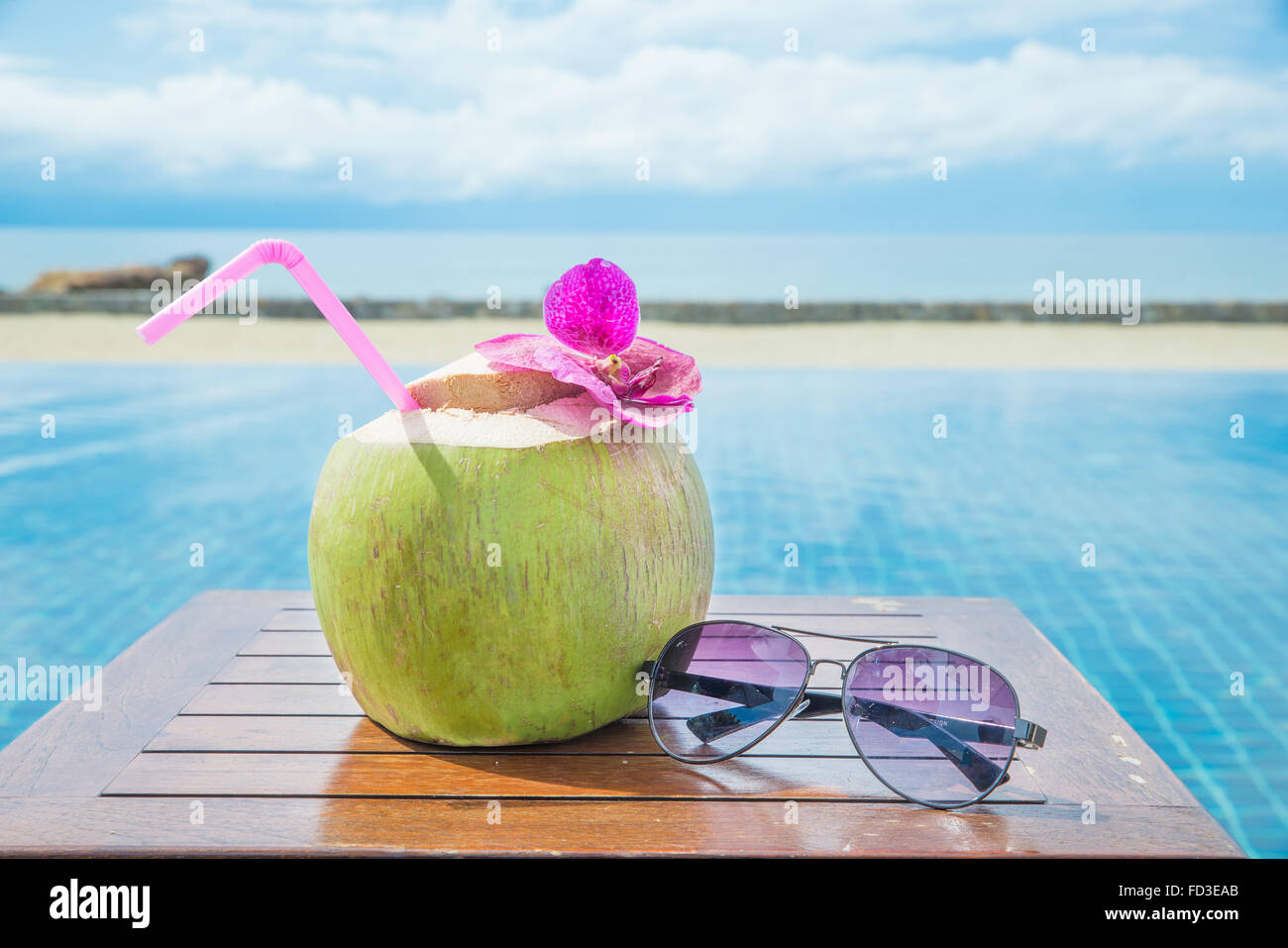 Sommer, Reisen, Urlaub und Ferien-Konzept - tropische frische Kokosnuss cocktail mit Pool und Strand im Ozean, Phuket, Thailand Stockfoto Sommer, Reisen, Urlaub und Ferien-Konzept - tropische frische Kokosnuss cocktail mit Pool und Strand im Ozean, Phuket, Thailand Stockfoto