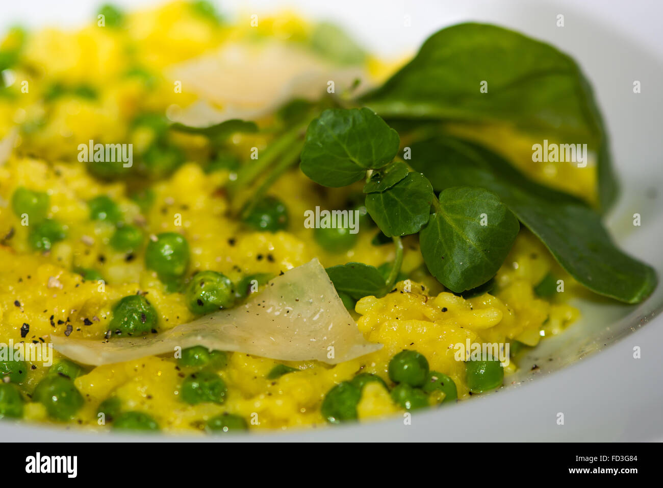 Lauch, Garten Erbsen und Safran-Risotto mit Parmesan-Käse. Französisches Restaurant, die Küche mit hellen gelben Reis Stockfoto