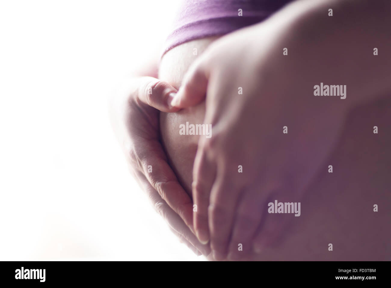 Hände formen ein Herz für die schwangere Mutter baby Bauch. Herz geformten Hände. Stockfoto