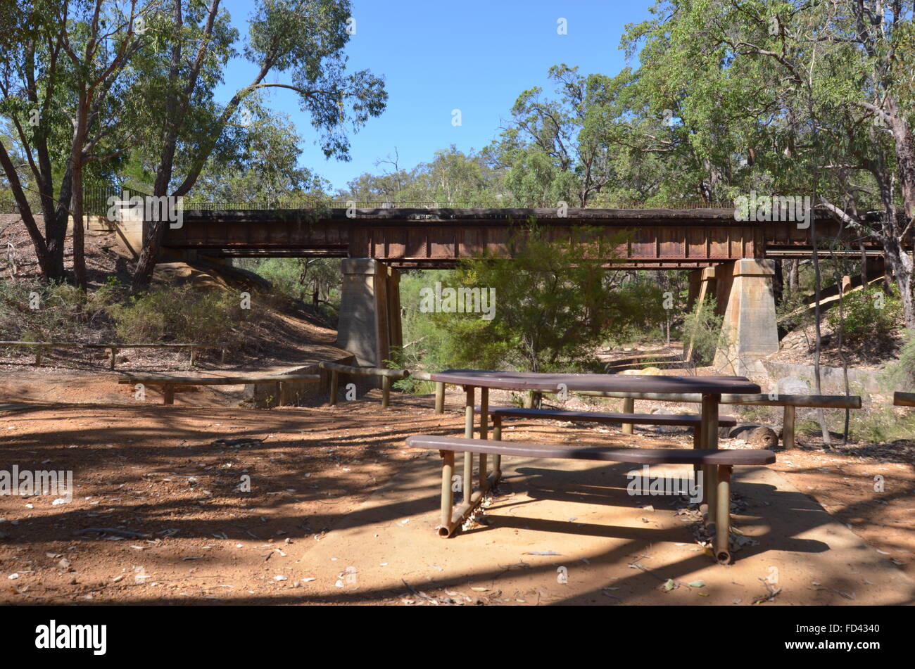Ein Picknick-Tisch und Brücke der Eisenbahn Reserven Heritage Trail in John Forrest Nationalpark, Western Australia Stockfoto