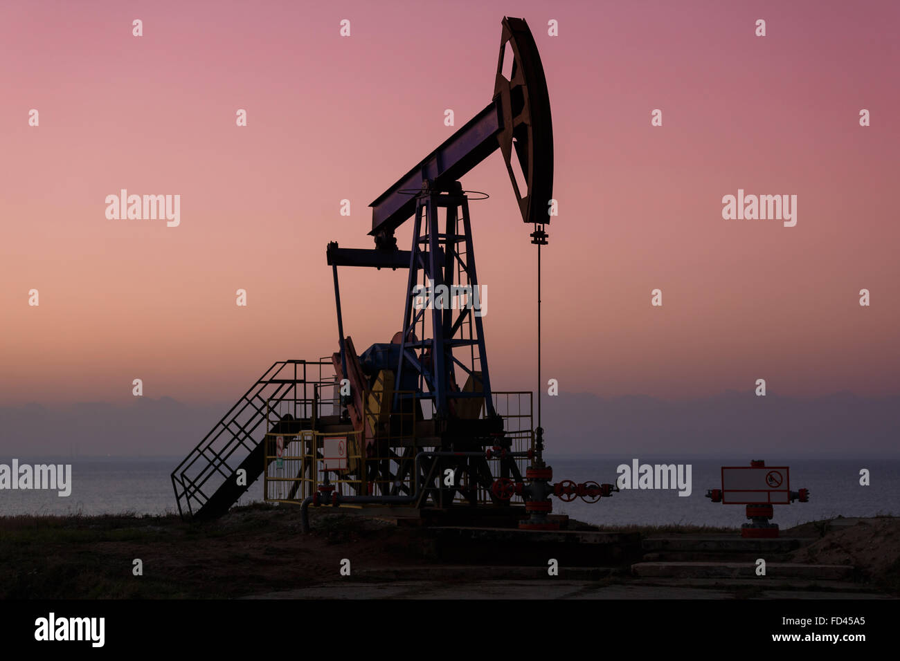 Öl-Bohrtürme auf dem Hintergrund des Sonnenuntergangs Stockfoto