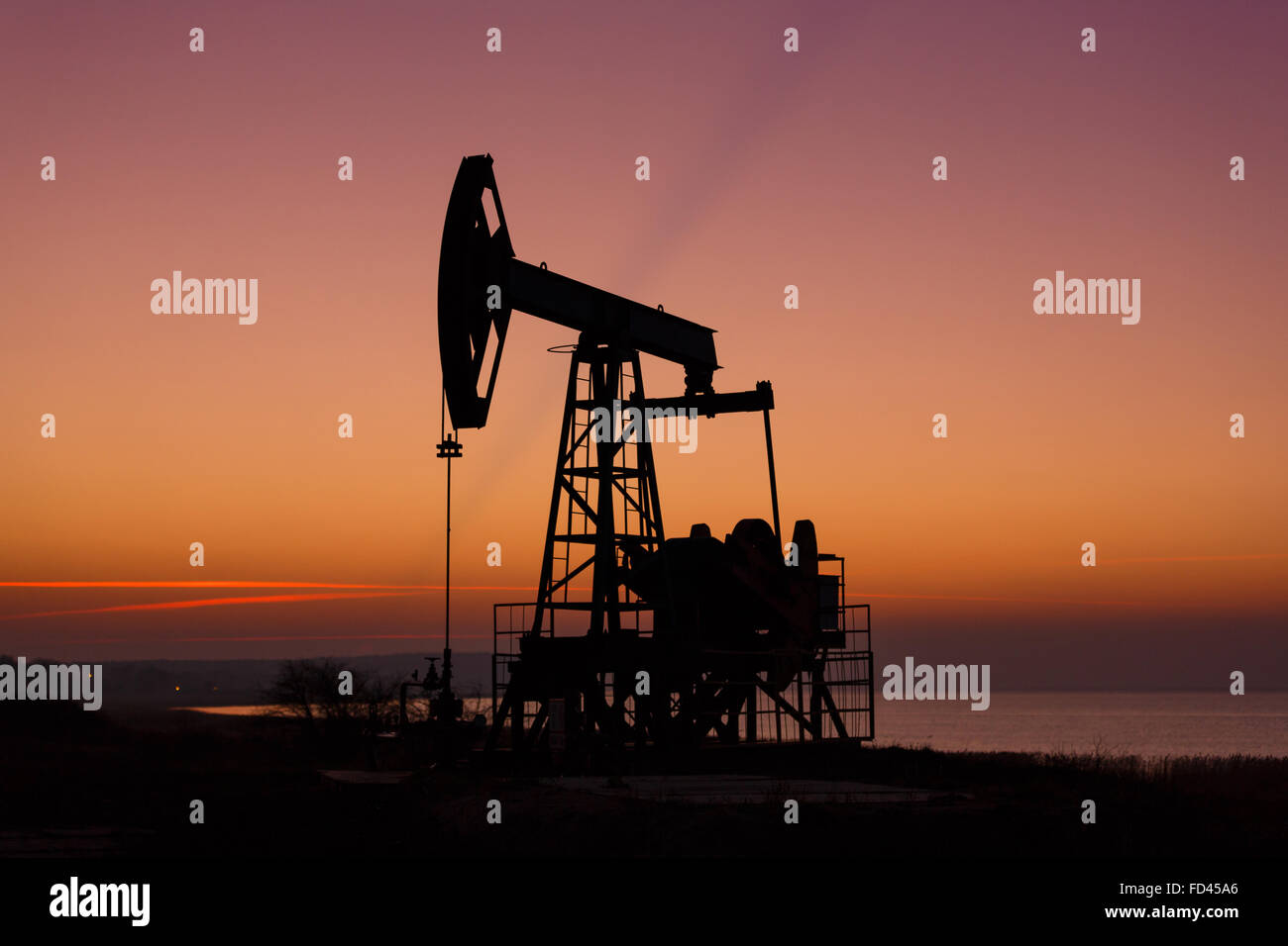 Öl-Bohrtürme auf dem Hintergrund des Sonnenuntergangs Stockfoto