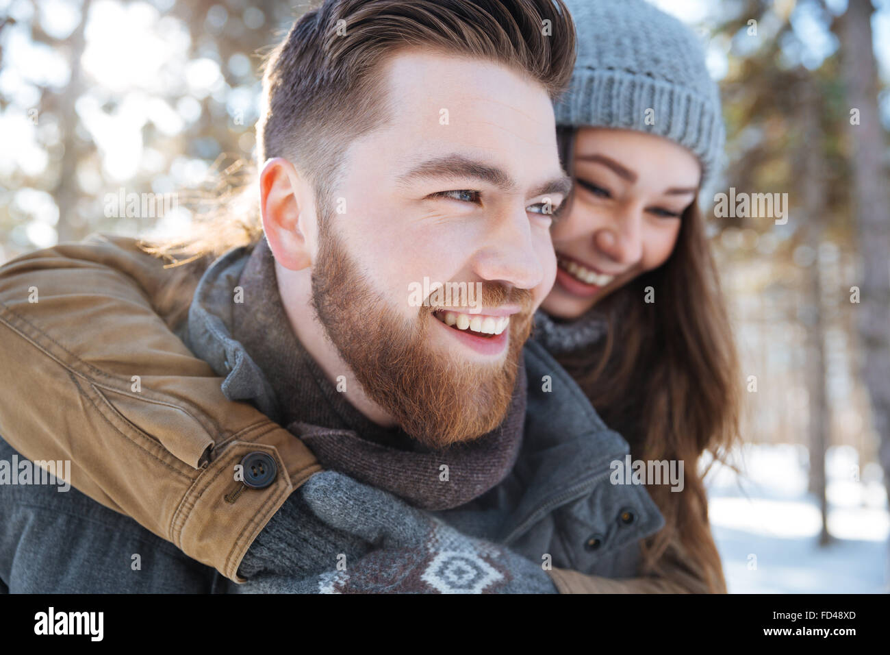 Lächelnde junge Paare, die Spaß in Winter park Stockfoto
