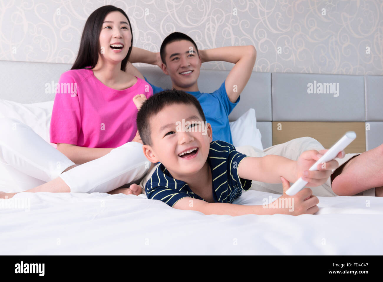 Familie vor dem Fernseher im Bett Stockfoto