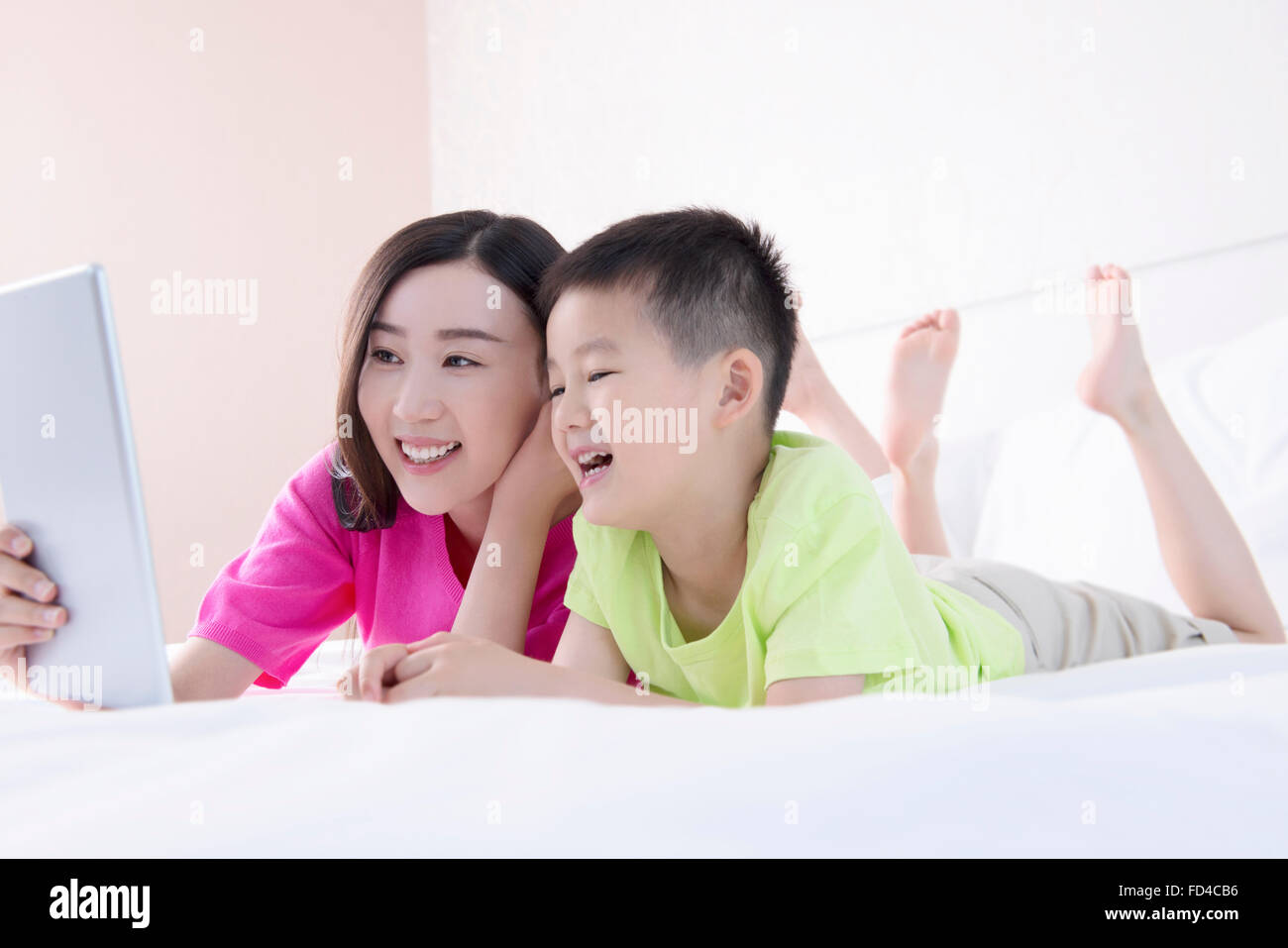 Mutter und Sohn mit digital-Tablette im Bett Stockfoto