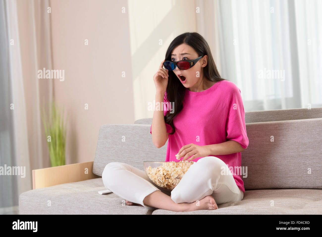 Junge Frau vor dem 3D Fernseher Stockfoto