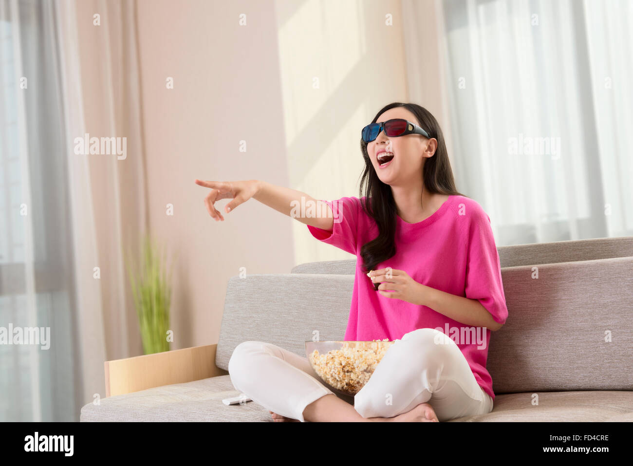 Junge Frau vor dem 3D Fernseher Stockfoto