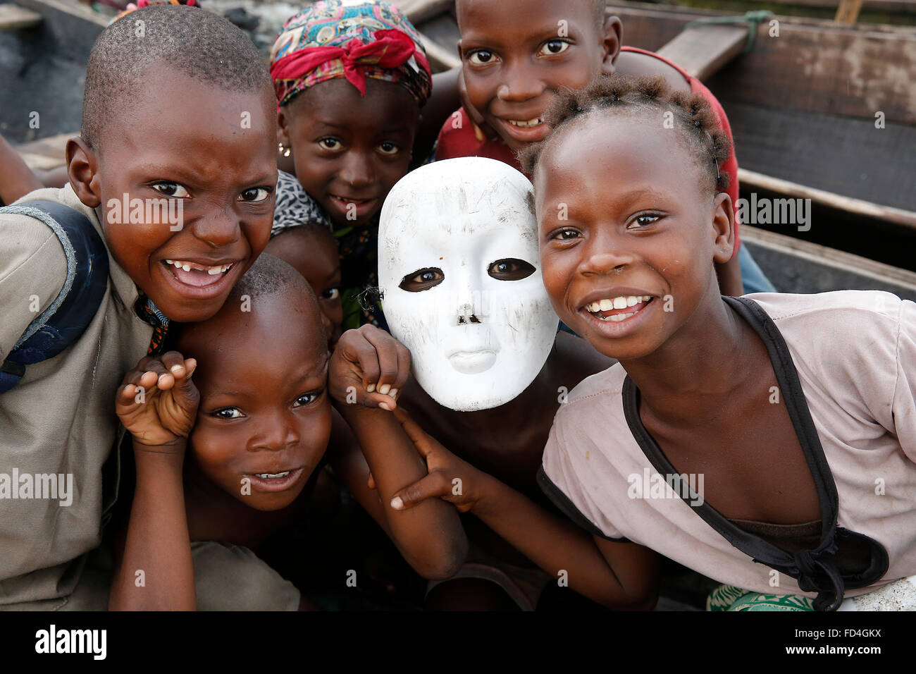 Benin-Kinder, von die einer eine weiße Maske trägt Stockfoto