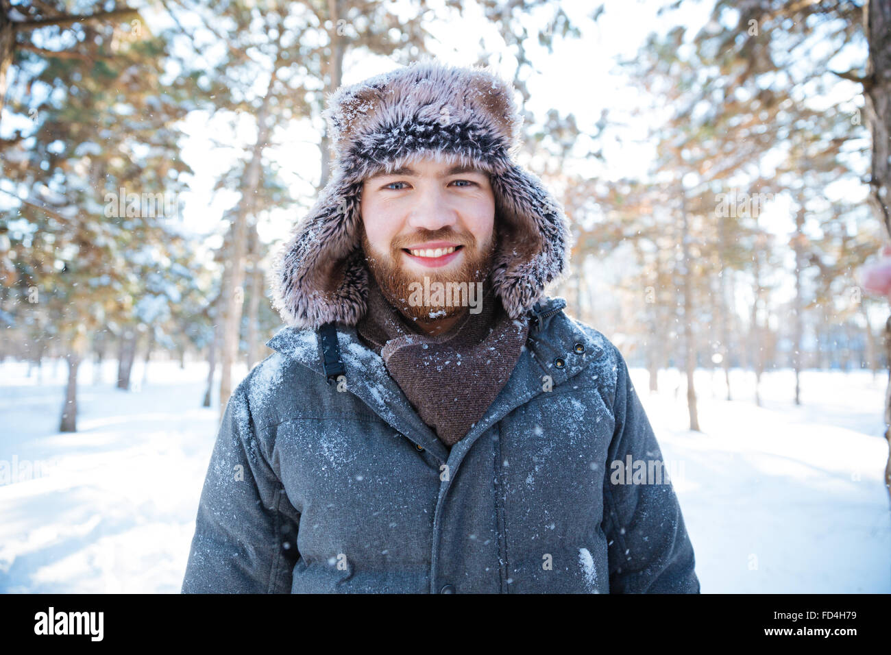 Gut aussehender Mann im Winter Tuch stehen im Freien und Blick in die Kamera Lächeln Stockfoto