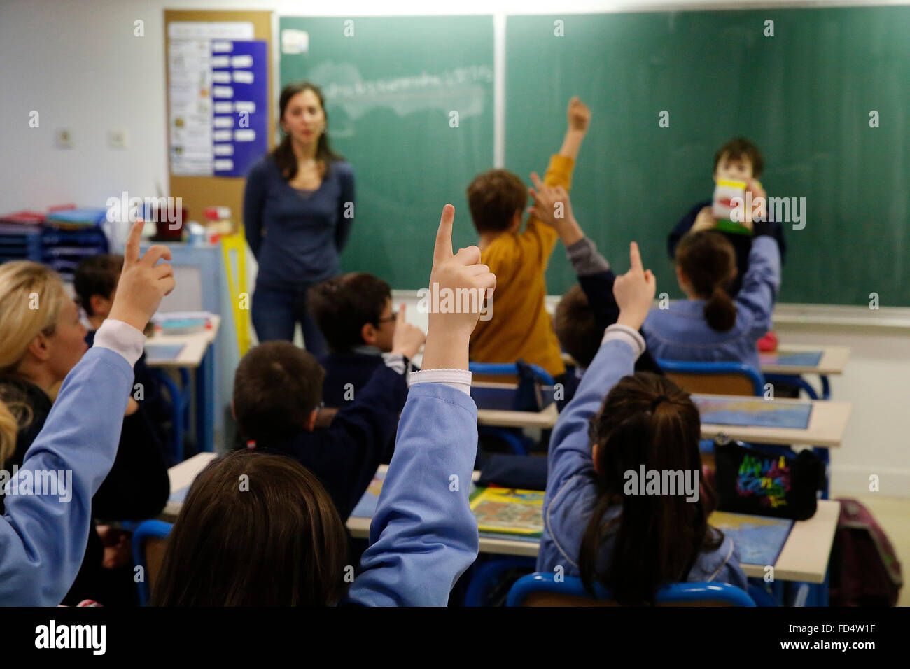 Grundschule. Schülerinnen und Schüler Hände erhebend Stockfoto