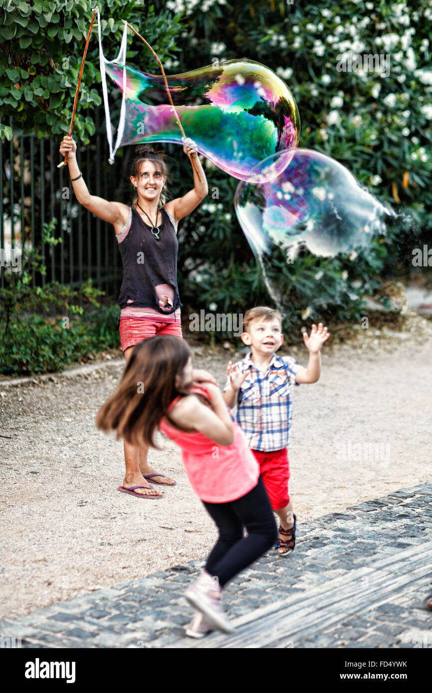 Kleine Kinder spielen mit riesige Seifenblasen in den Straßen von Athen, Griechenland Stockfoto
