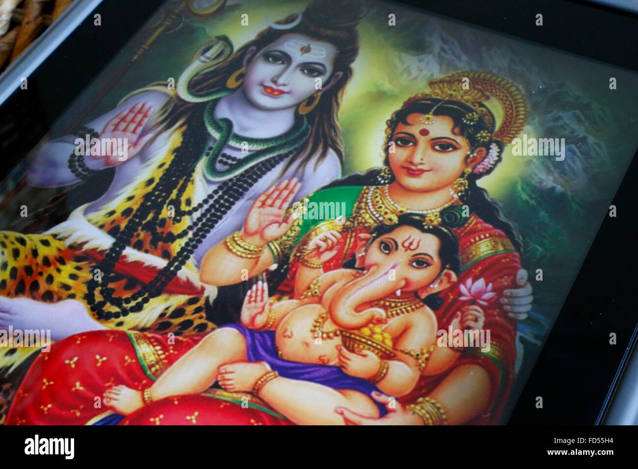 Hindu-Gottheiten auf einem Ipad. Ganesha. Ganesha und seine Eltern: Parvati und Shiva. Stockfoto