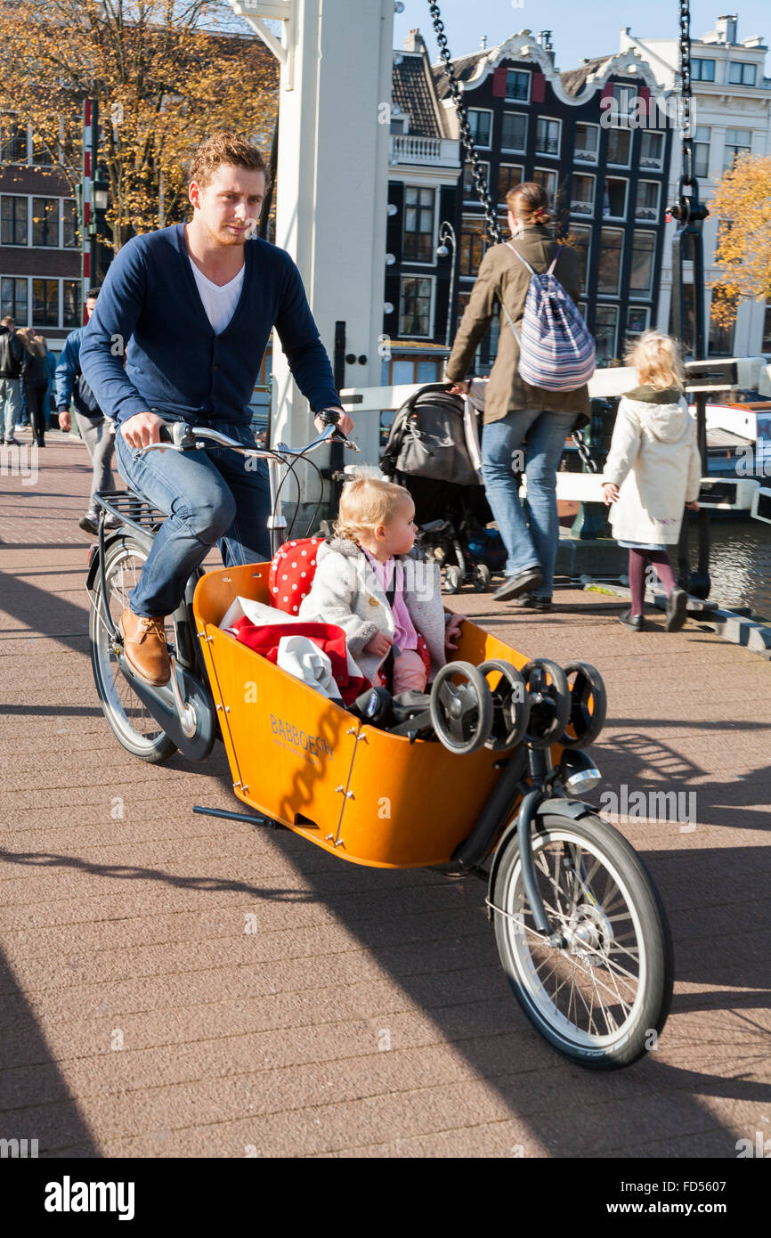 Mutter - Vater - Kind tragen / Kinder / Kind / Kinder in einem  niederländischen Fahrrad Fahrradträger / Cargo-box "Bakfiet". Amsterdam,  Niederlande. Holland Stockfotografie - Alamy