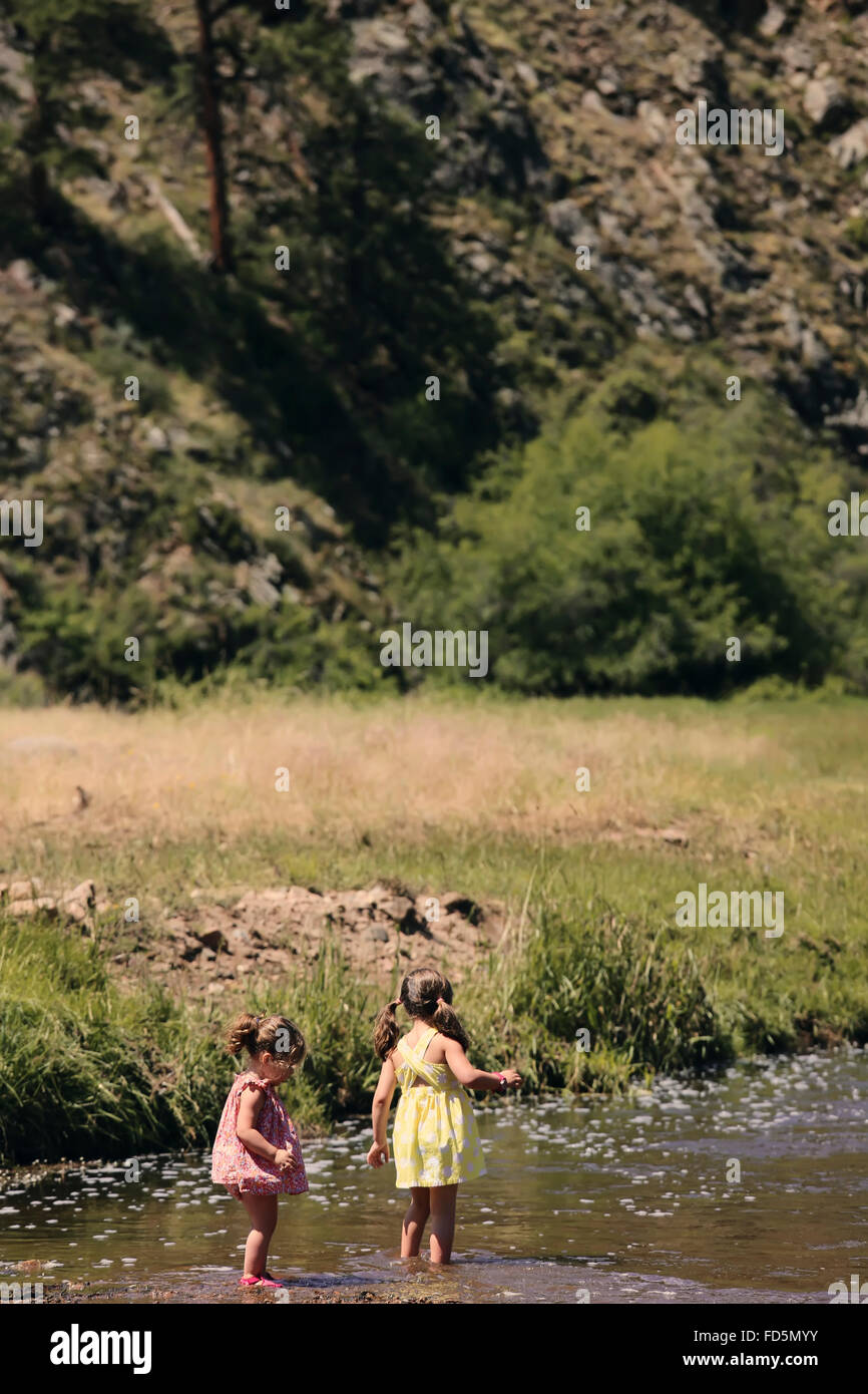 Zwei junge Mädchen stehen in einem Fluss, die Natur zu erkunden. Stockfoto
