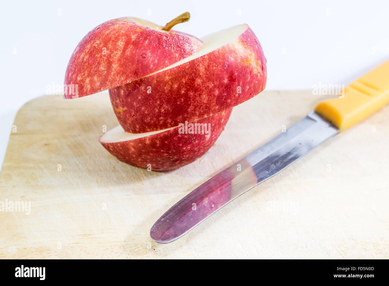 Schneiden Sie die Äpfel mit einem Messer in Stücke. Stockfoto