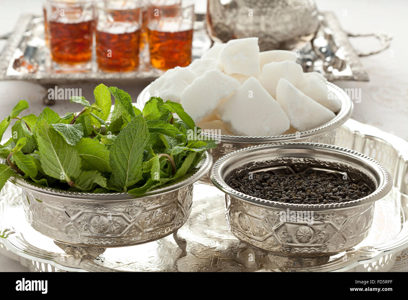 Marokkanischer Tee-Set mit Zucker, Minze und Tee in traditionellen Schalen Stockfoto
