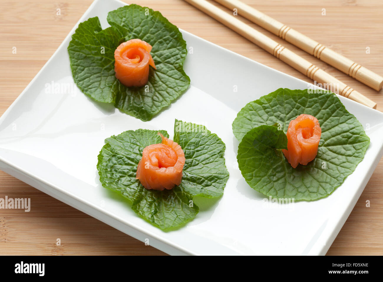 Japanische Vorspeise geräucherten Lachs auf Wasabi-Blätter Stockfoto