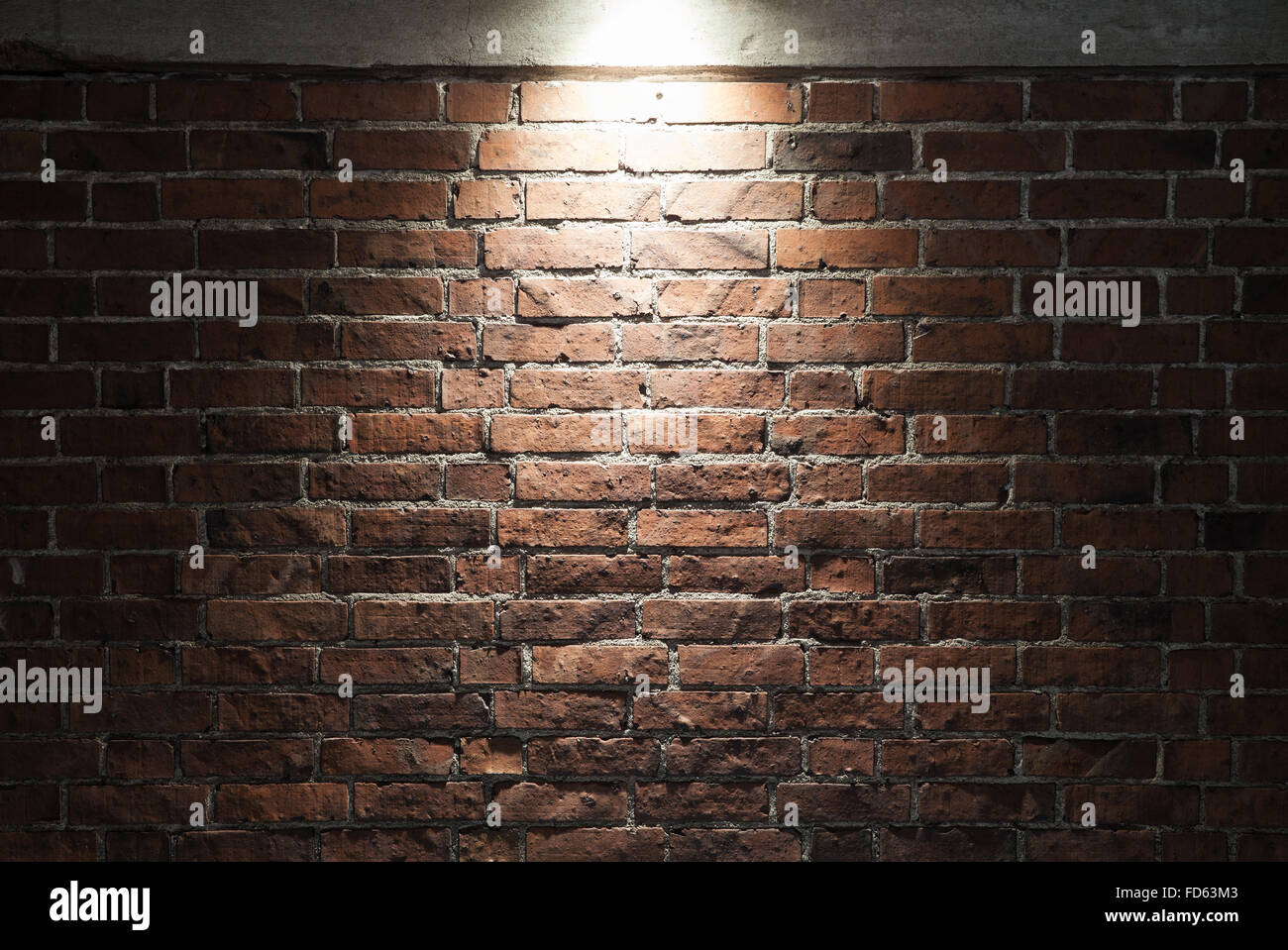Grunge dunklen roten Backsteinmauer mit Spotlight Hintergrundtextur Foto Stockfoto