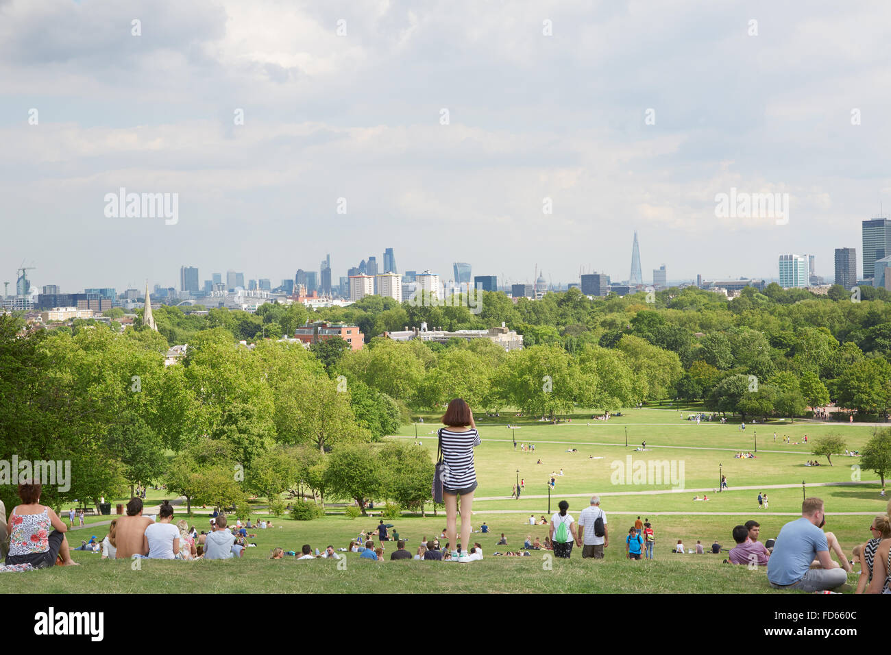 Primel-Hügel mit Blick auf die Stadt London und Menschen entspannen im Park, junge Frau nimmt Bilder Stockfoto