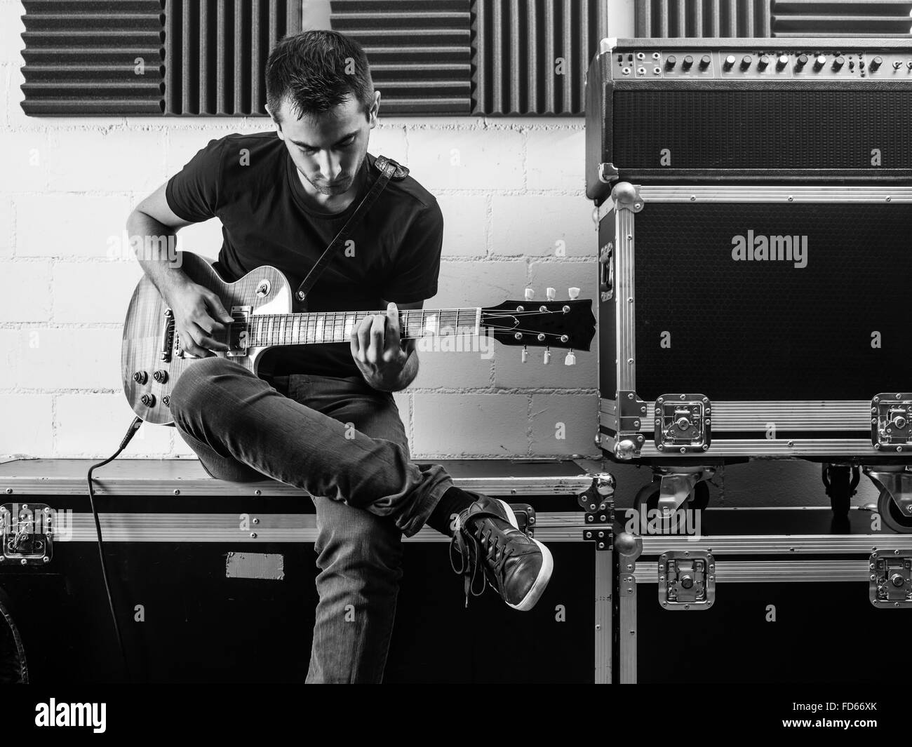 Foto von einem Mann sitzen backstage seine Gitarre zu üben. Stockfoto