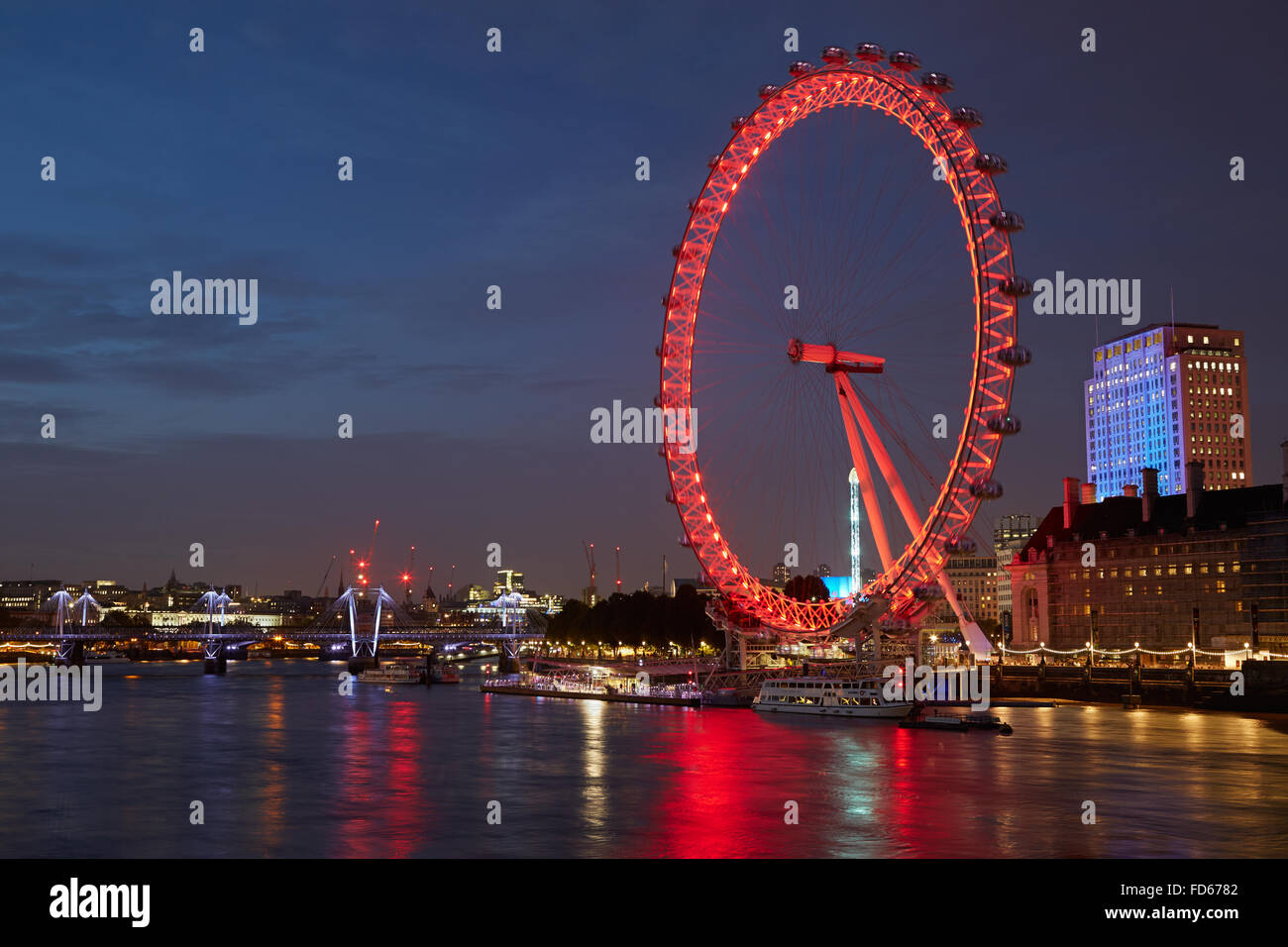 London Eye, Riesenrad, in rot und Blick auf den Fluss Themse in der Nacht beleuchtet Stockfoto