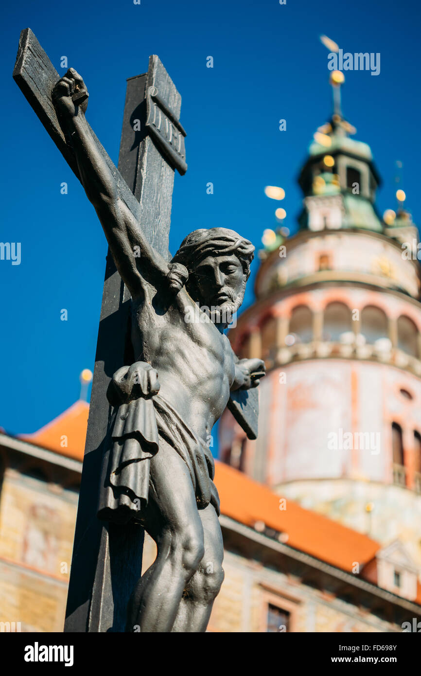 Die Statue des gekreuzigten Christus am Kreuz auf Lazebnicky die meisten Brücke im Hintergrund der alte Schlossturm in Cesky Krumlov, Tschechische Stockfoto