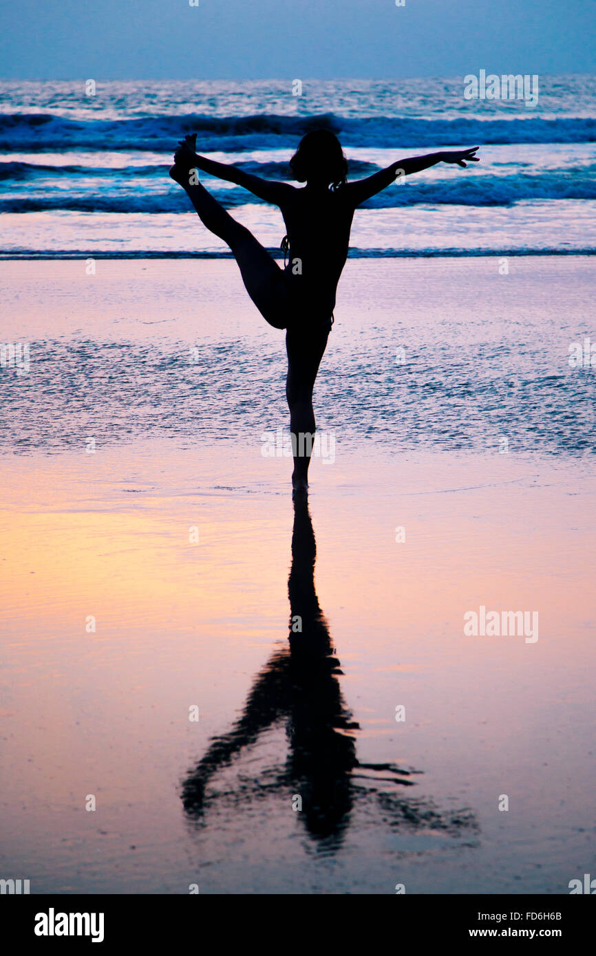 Junge Frau praktizieren Yoga am Strand in Agonda, Goa, Indien Stockfoto