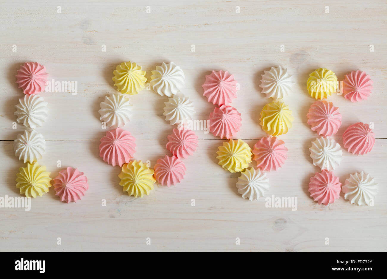 Aufschrift Liebe Baiser gemacht der Pastell-Farben auf weißem Hintergrund aus Holz. Bild der Valentinstag Stockfoto