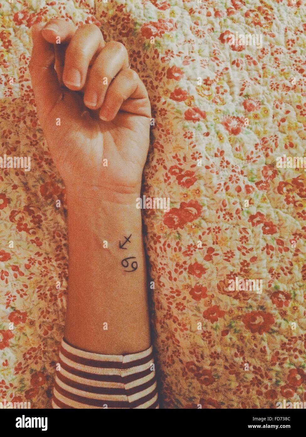 Bild der Frau Hand mit Tattoo auf Bett beschnitten Stockfoto