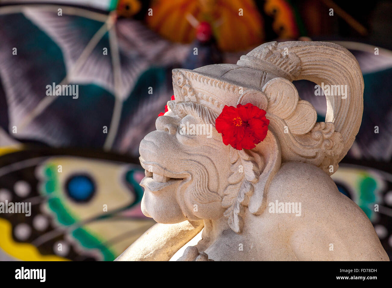 Affengott Hanuman aus Stein mit roten Hibiskus Blumen, weißer Kalkstein, Hanuman, Hinduismus geschnitzt, hinduistische,,, Straße Szene, Ubud, Stockfoto